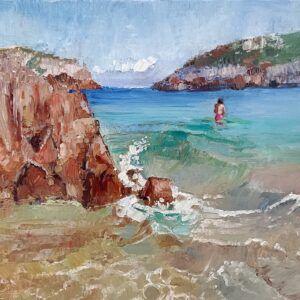 El bañador fucsia, paisaje de playa asturiana con orilla de arena terrosa, rocas rompiendo olas, montañas rocosas con vegetación, mar en tonos ocre, rosa, verde esmeralda, turquesa y azul, muchacho de bañador fucsia avanzando, cielo azul con nube blanca, óleo al agua 23x30 cm