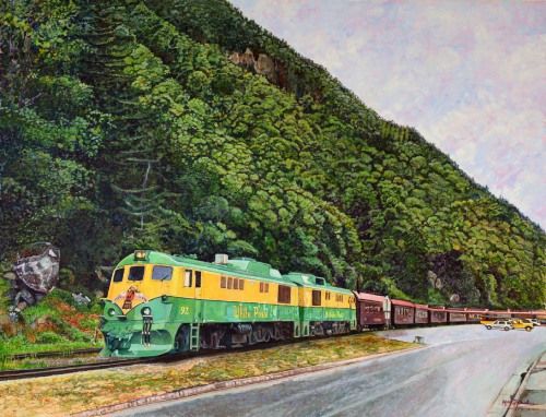 El encanto de los trenes, acrílico sobre lienzo de lino de 89x116 cm. Paisaje de Alaska con tren vintage en tonos verdes, amarillos y vagones marrón rojizo. Vía de tren con carretera gris mojada a un lado. Montaña rocosa cubierta de árboles verdes. Coches y vehículos aparcados al fondo.