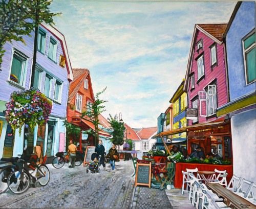 Paseo por Noruega, acrílico y óleo sobre lienzo de algodón de 81x100 cm. Calle empedrada con casas de colores, tiendas y restaurantes con terrazas llenas de gente. Pizarras verdes con menús, bicicletas aparcadas, farola con macetas. Hombre bajándose de una bicicleta, pareja con carrito de niño, comensales en terrazas.